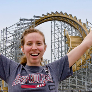 woman standing in front of wooden roller coaster