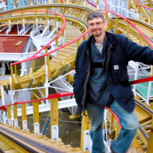 man stands on roller coaster lift hill